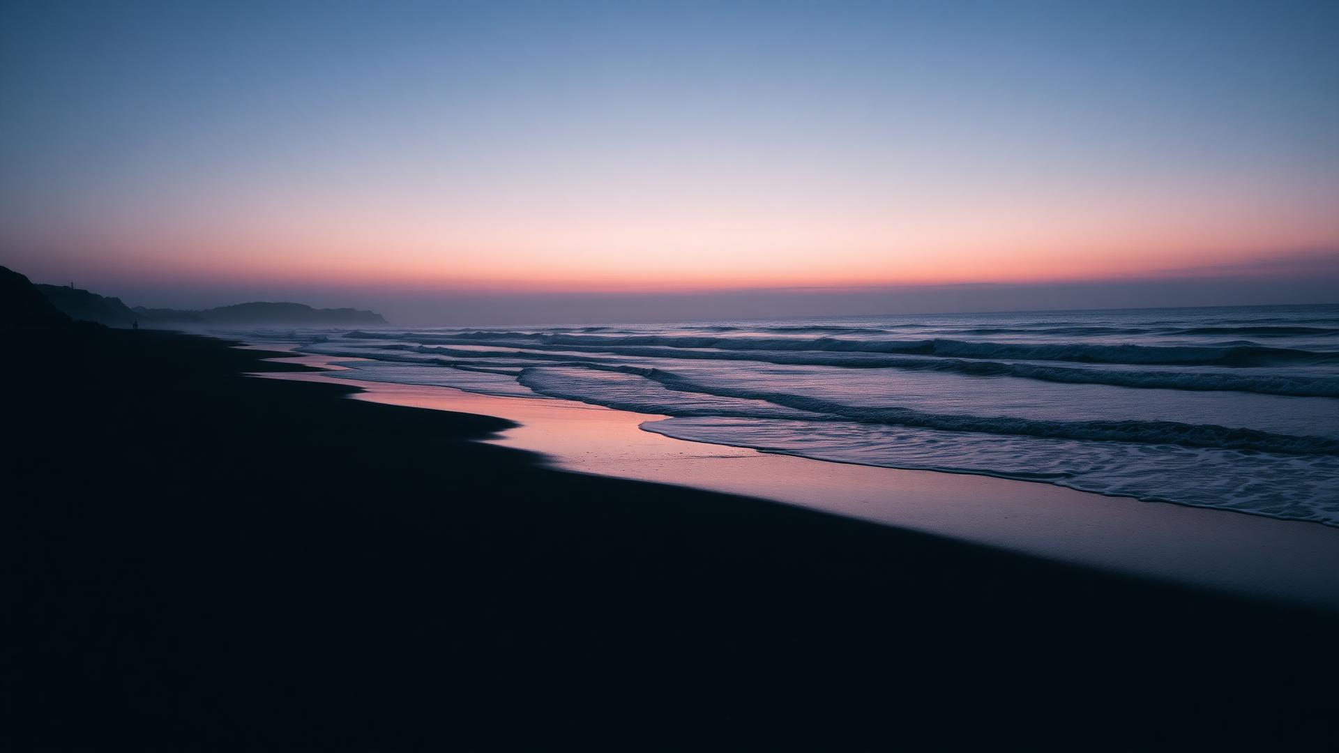 Dusk coastline with dark sand and breaking surf